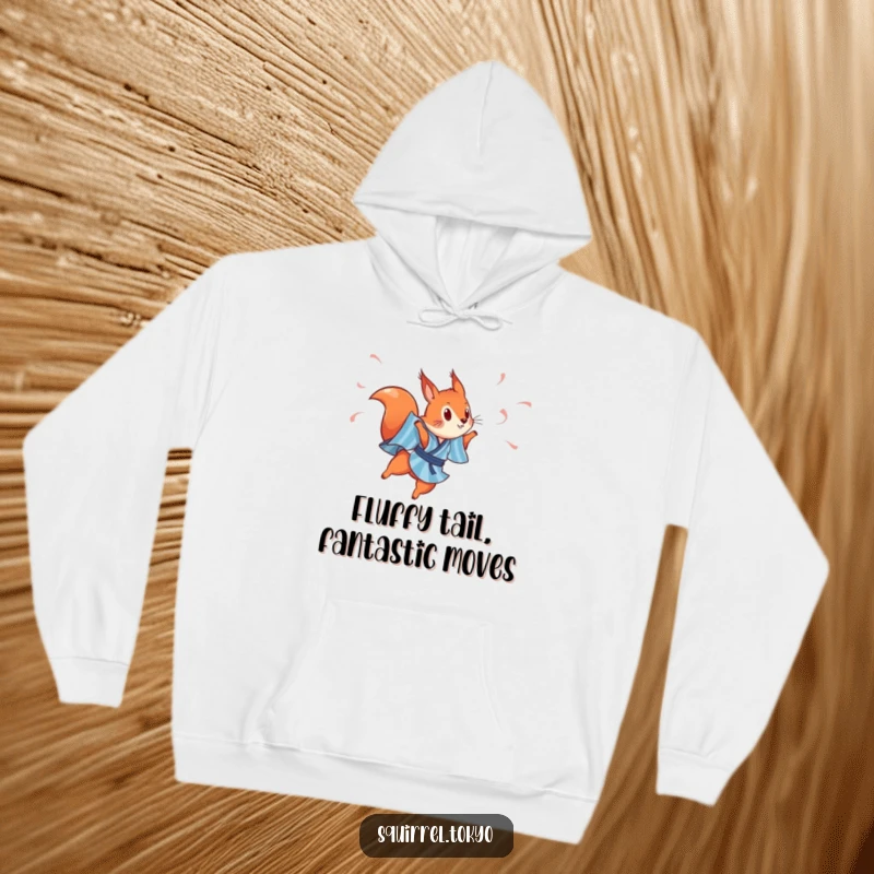 Funny hoodie depicting a playful red squirrel in a blue striped kimono, leaping with streamers, perfect for staying warm and inspired.